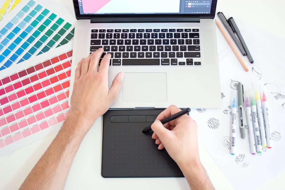 Designer working with a drawing tablet and colour swatches
